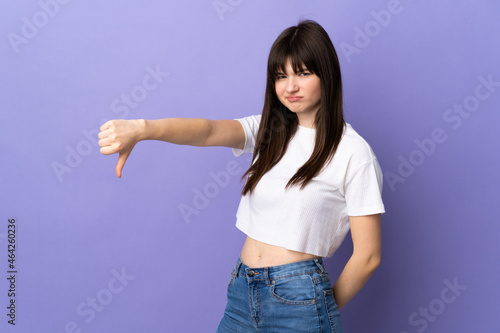 Young Ukrainian woman isolated on purple background showing thumb down with negative expression