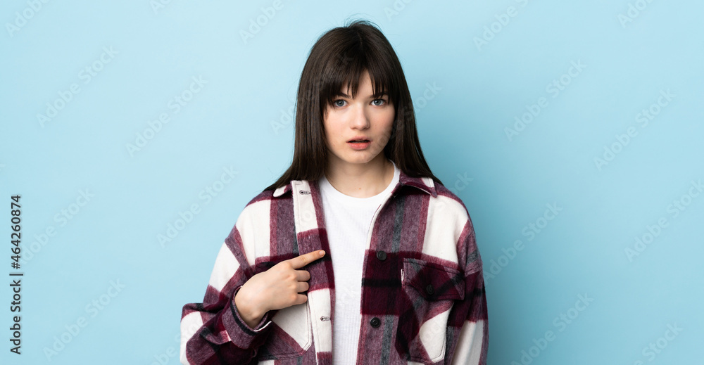 Teenager Ukrainian girl isolated on blue background pointing to oneself Teenager Ukrainian girl isolated on blue background pointing to oneself