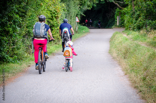 Caucasian family of two adults and a child riding bikes on Camel Trail in Cornwall from Widebridge towards Padstow, England, UK