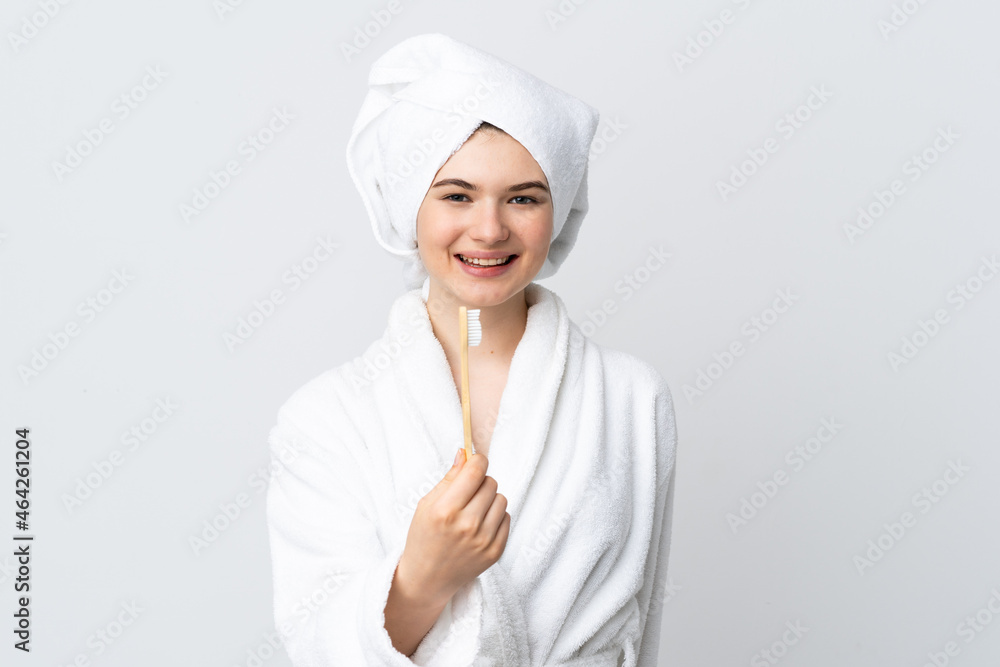 Young woman in a bathrobe holding toothbrush with happy expression Young woman in a bathrobe holding toothbrush with happy expression