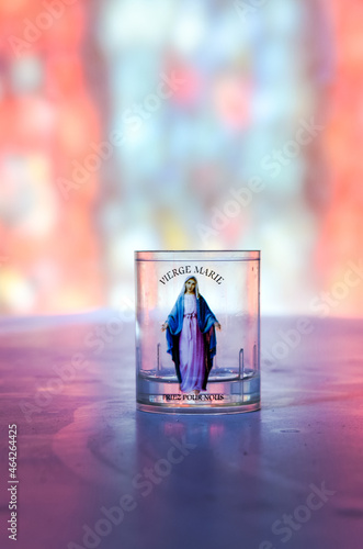 veilleuse bougie vierge Marie illuminée par les vitraux dans une église