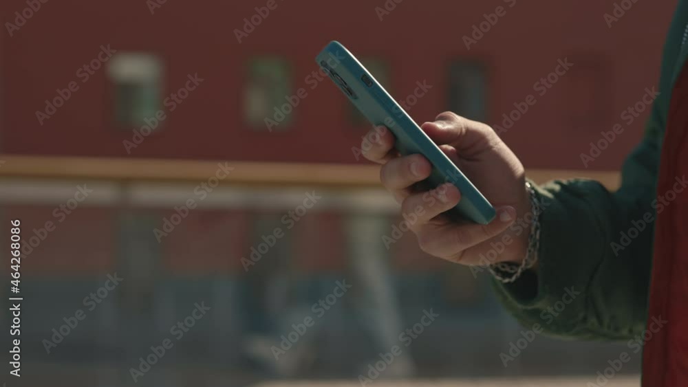 Close up of male person walking and texting on smartphone Close up of male person walking and texting on smartphone