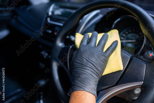 Man wearing gloves to clean the dashboard of the car. Auto Service. © PBXStudio