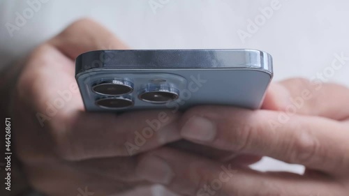 New Iphone 13 Pro smartphone model in light blue color filmed in use. Young man using trendy mobile phone in close up video clip