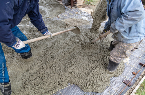 Workers level out the concrete mix at a construction site.