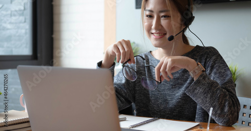 Cropped shot smiling asian woman freelancer wearing headset, communicating with client via video computer call. Millennial pleasant professional female tutor giving online language class