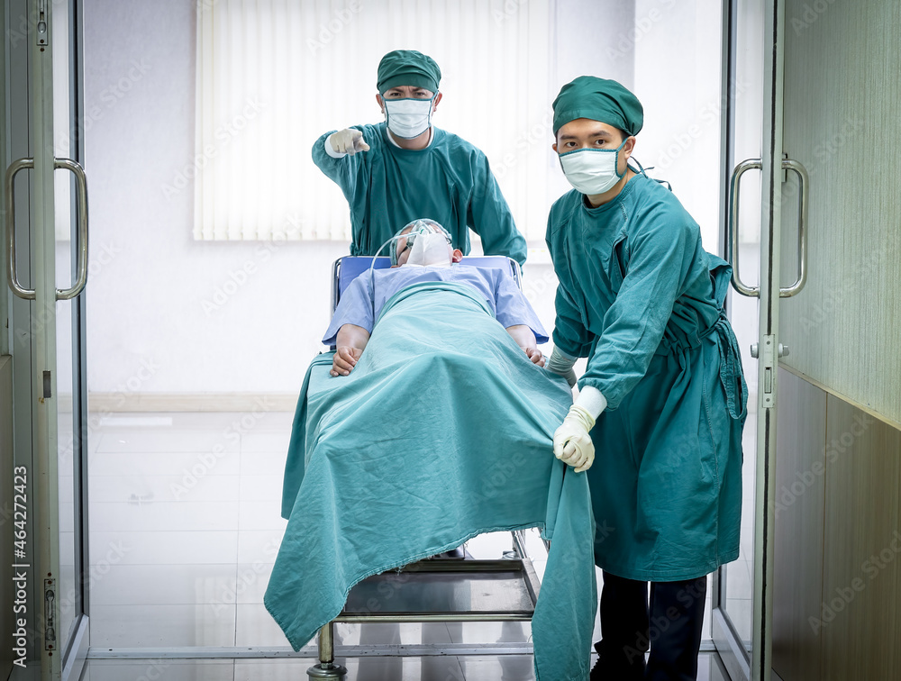 Team of doctors in a hurry carrying a stretcher with a patient with an oxygen mask to the operation theatre.. Team of doctors in a hurry carrying a stretcher with a patient with an oxygen mask to the operation theatre..