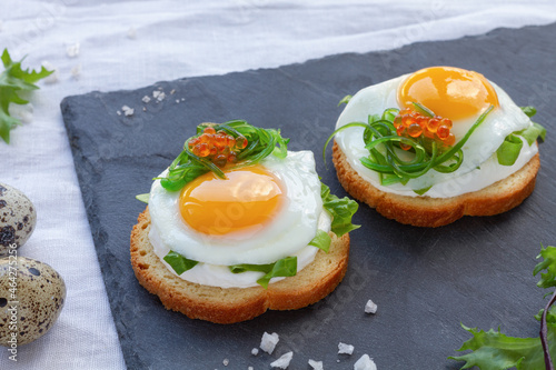 Delicious toasts with fried quail eggs photo