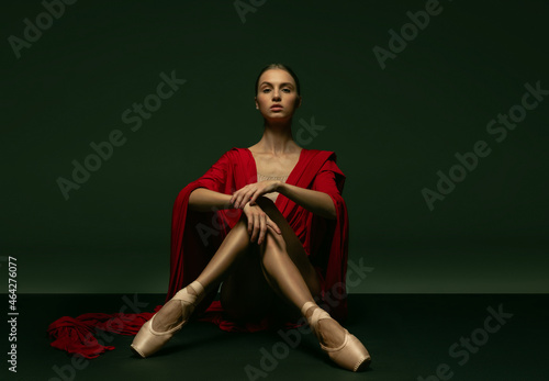 Graceful classic ballerina posing like greek goddess isolated on dark studio background. Grace, art, performance concept.