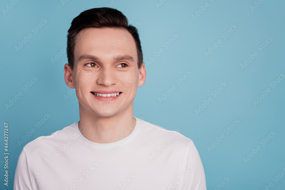 Photo of cheerful young man beaming smile wondered look empty space isolated on pastel blue color background Photo of cheerful young man beaming smile wondered look empty space isolated on pastel blue color background