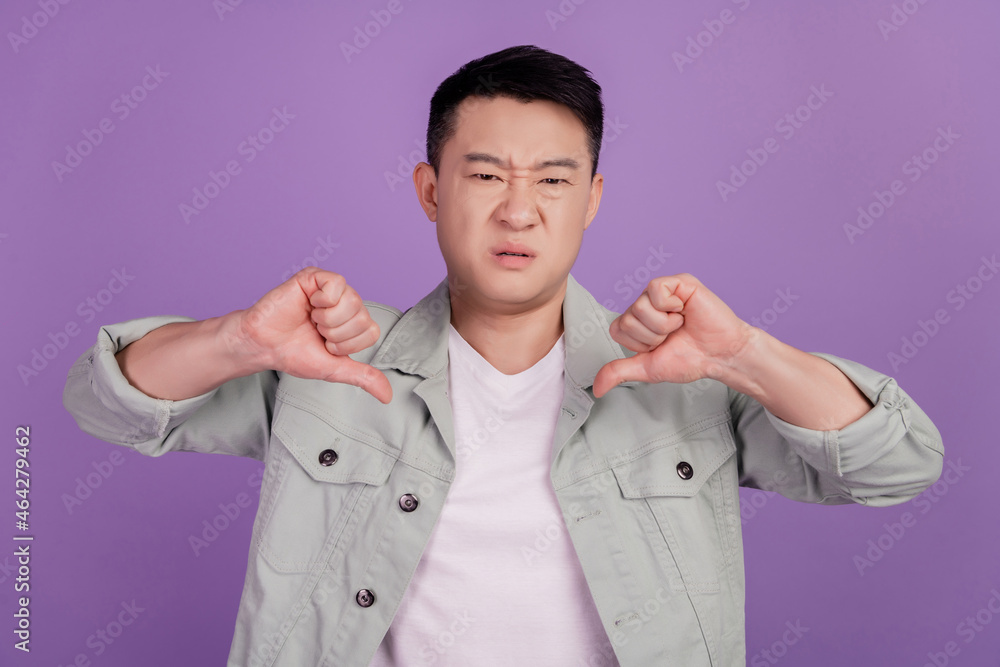 Disappointed korean man show thumb down express decision disagreement Disappointed korean man show thumb down express decision disagreement
