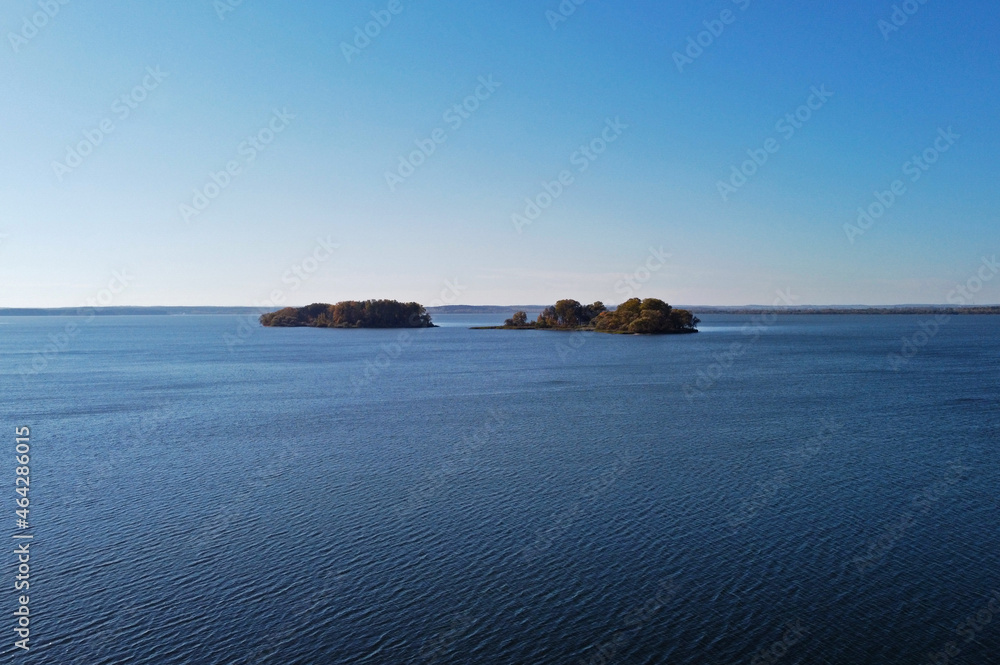 Island in the sea with a beautiful autumn forest. Aerial top view