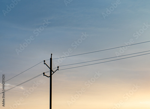 Electricity pole over blue and orange sky minimal photo.