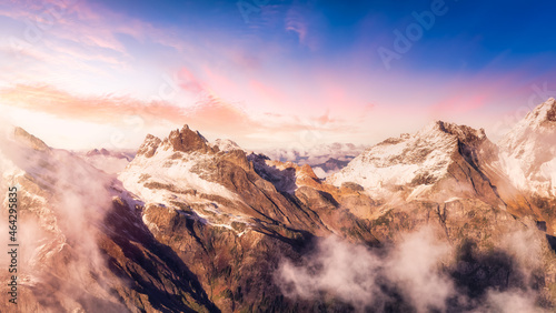Aerial View of Canadian Rocky Mountains with snow on top. Colorful Sunset Sky Art Render. Nature Landscape located near Chilliwack, East of Vancouver, British Columbia, Canada.