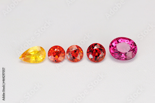 Natural colored gemstones set lot on white background. Yellow sapphire, deep orange color spessartine garnets, pink tourmaline loose faceted stone setting. Oval, round, drop shaped.  Gemology theme. photo