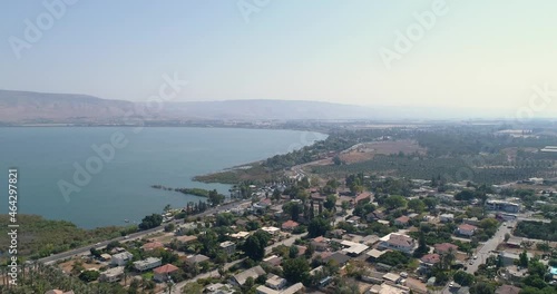 Aerial shot at sunset above Golan Heights and Tiberias with Galilee sea or Kinneret at Jordan valley in North of Israel. Drone above open fields with orange green landscapes and mountains with clear