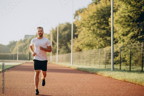 Man athlete jogging at stadium in the morning