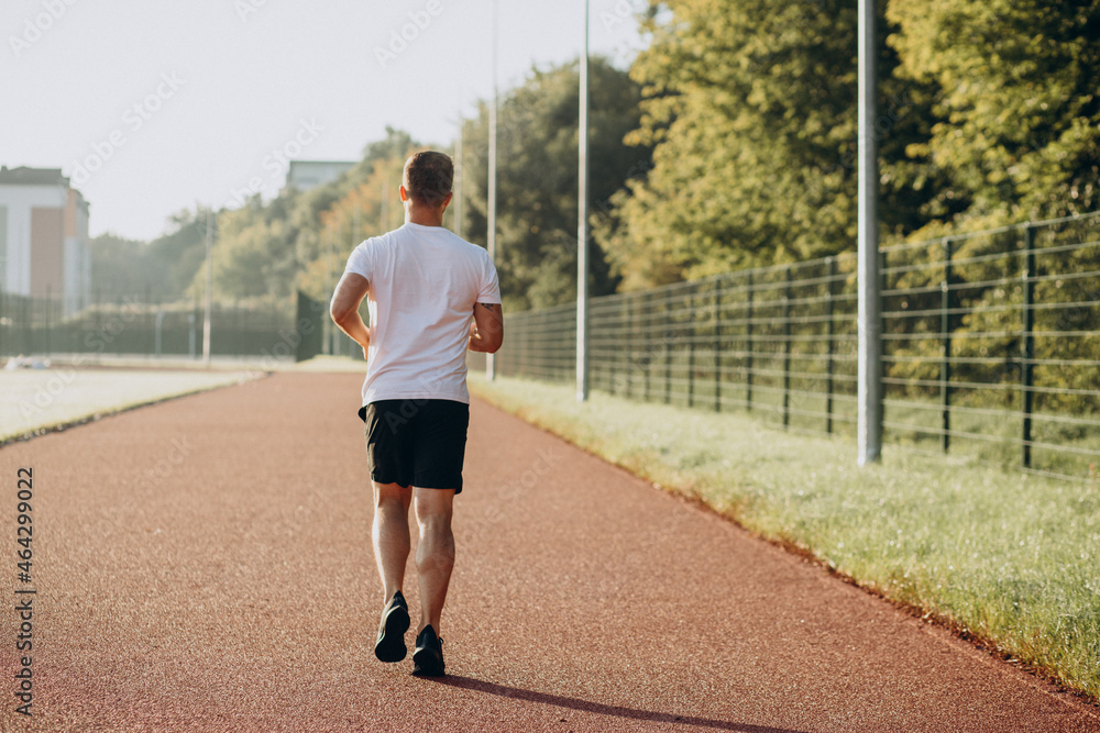 Man athlete jogging at stadium in the morning