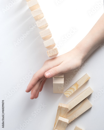 Close-up of fingers prevents the jenga wood block from falling