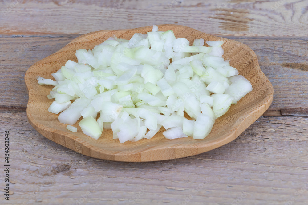 Sliced onion in a wooden plate - in the process of cooking Sliced onion in a wooden plate - in the process of cooking