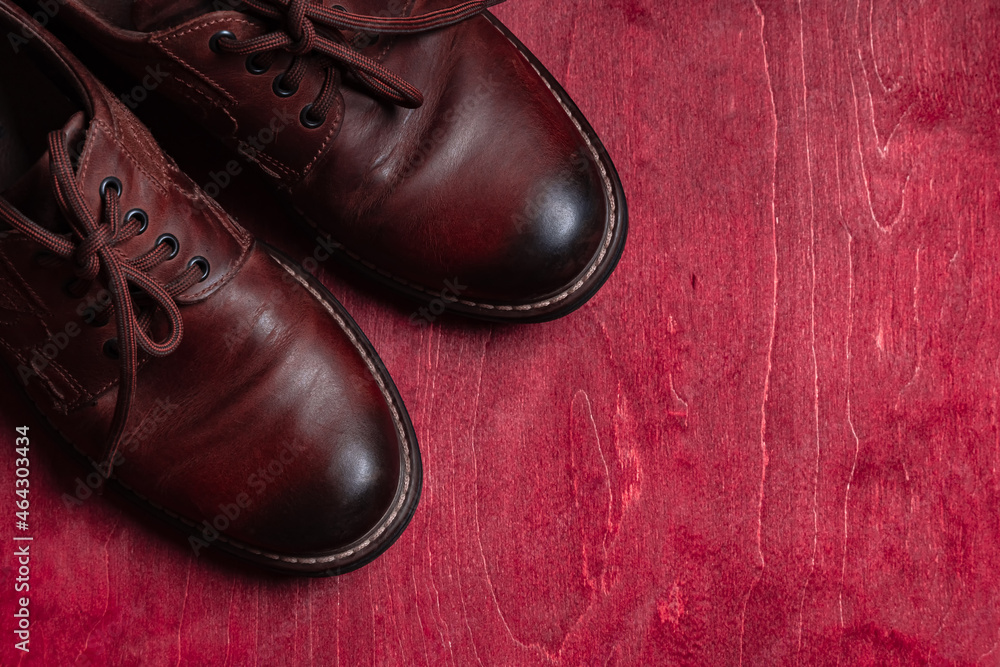Worn men's leather shoes on the red wooden floor. Worn men's leather shoes on the red wooden floor.