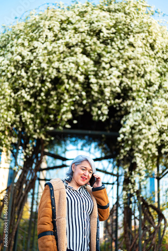 Portrait of a woman at the park with flowers at the background