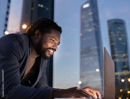 businessman with laptop at night buildings