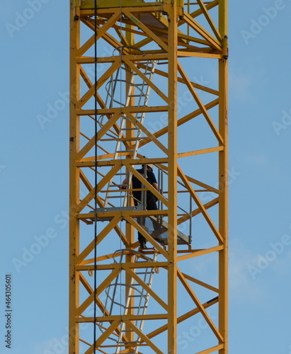 crane operator descends from a tower crane at the end of work