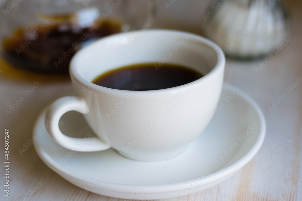 Delicious americano coffee with sugar in a white cup in a coffee shop Delicious americano coffee with sugar in a white cup in a coffee shop