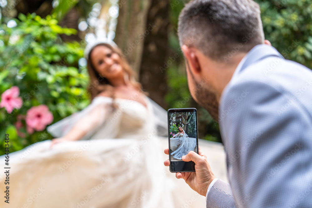 Faceless groom taking photo of positive bride Faceless groom taking photo of positive bride