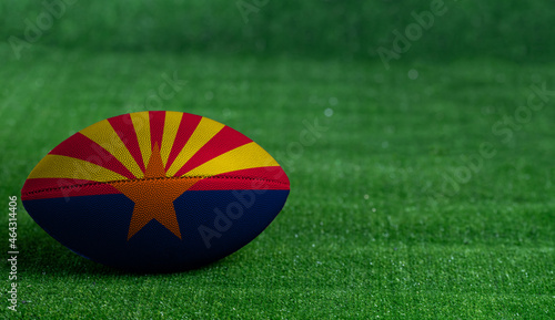 American football ball  with Arizona flag on green grass background  close up