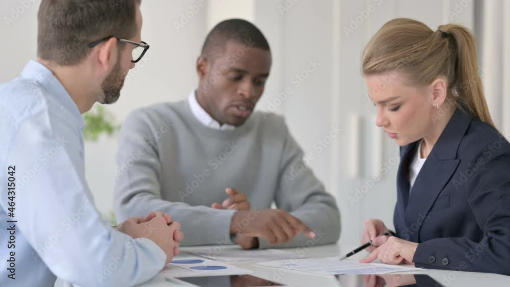 Male and Female Business Person Discussing Documents in Office Male and Female Business Person Discussing Documents in Office