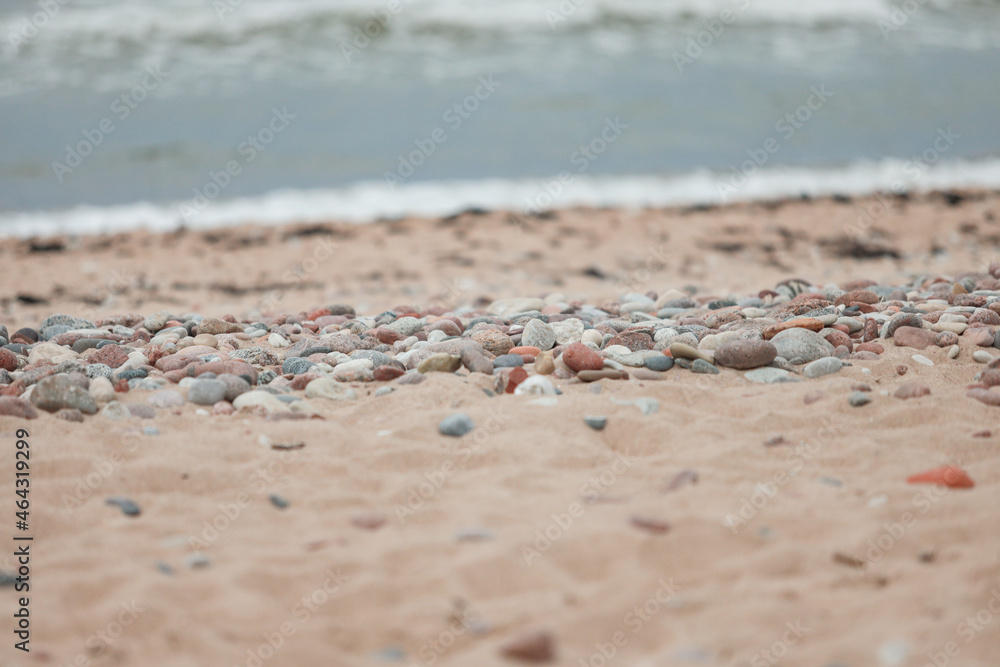 Close up view with sand and rocks on shoreline near baltic sea.