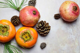 Top view, autumn fruit, persimmon and pomegranate, on marble background.