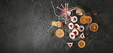 Tasty Linzer cookies with spices and candy canes on dark background with space for text