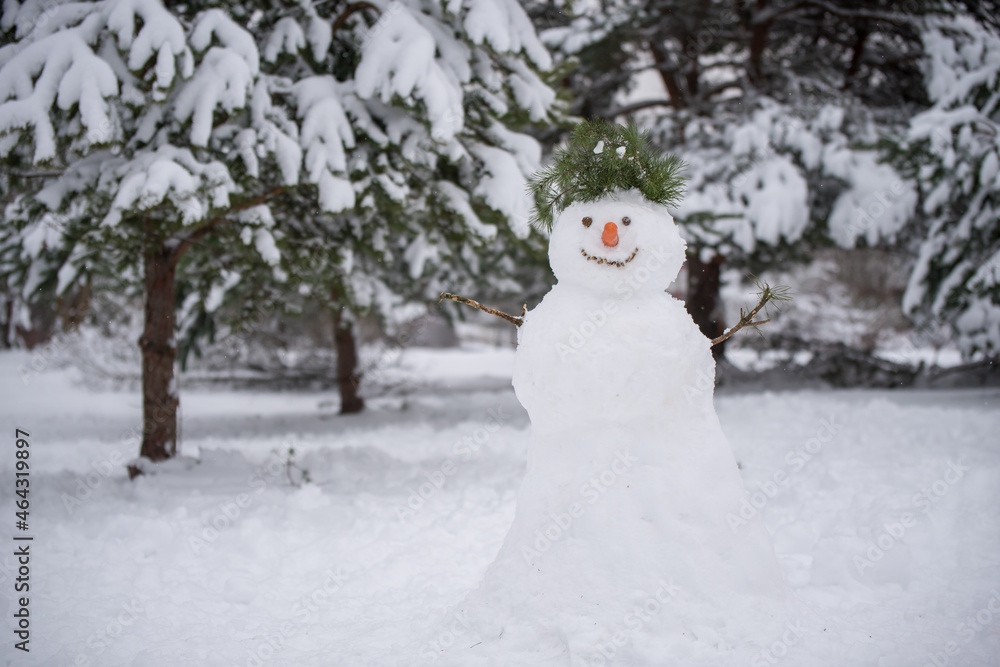 Obraz premium Funny snowman in a forest on a snowy winter walk