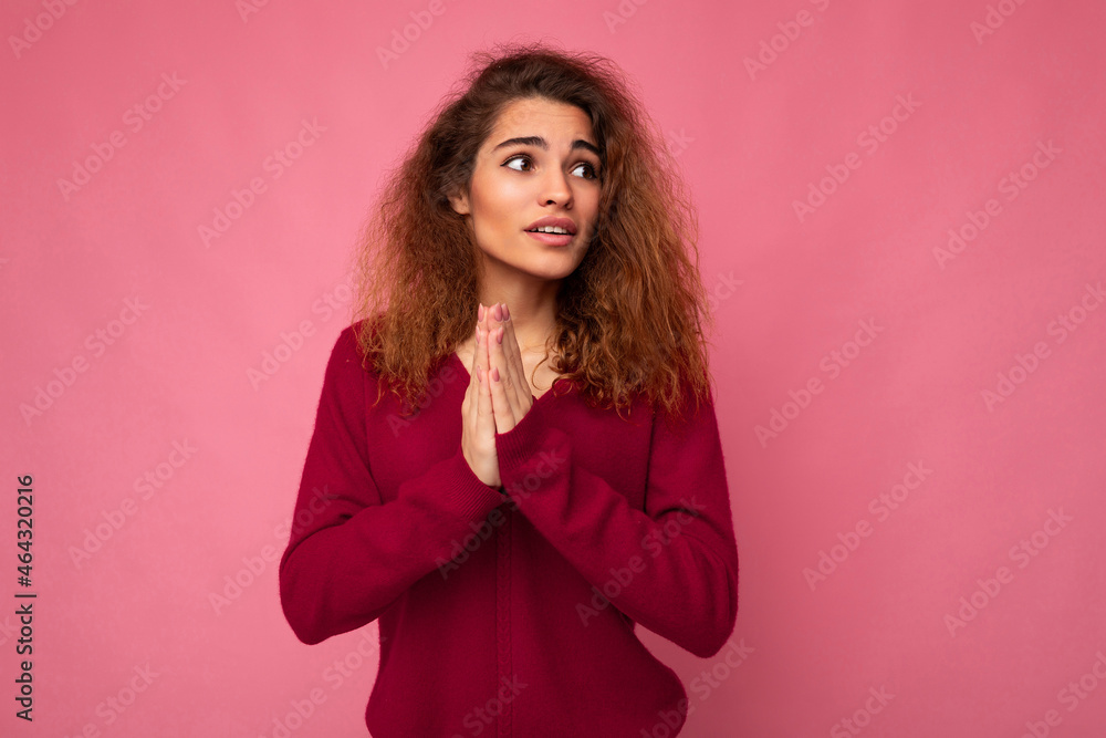 Photo of young emotional beautiful brunette curly woman with sincere emotions wearing trendy pink pullover isolated over pink background with free space and praying with hands holding together askinf Photo of young emotional beautiful brunette curly woman with sincere emotions wearing trendy pink pullover isolated over pink background with free space and praying with hands holding together askinf