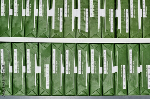 Copy paper reams with generic brand green packaging stacked up in rows on office shelves. photo