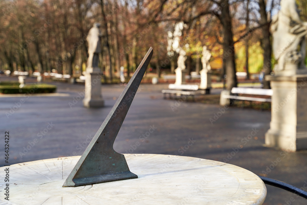 Old solar clock in Warsaw park at autumn