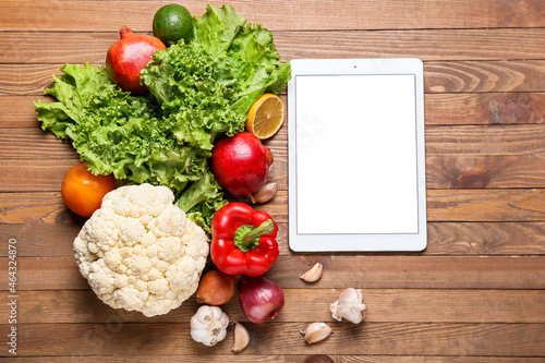 Digital recipe book, different vegetables and fruits on wooden background