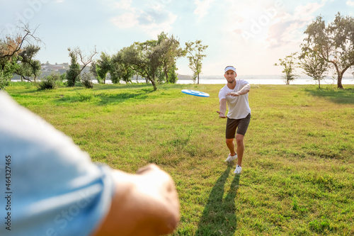 Young men playing frisbee i...