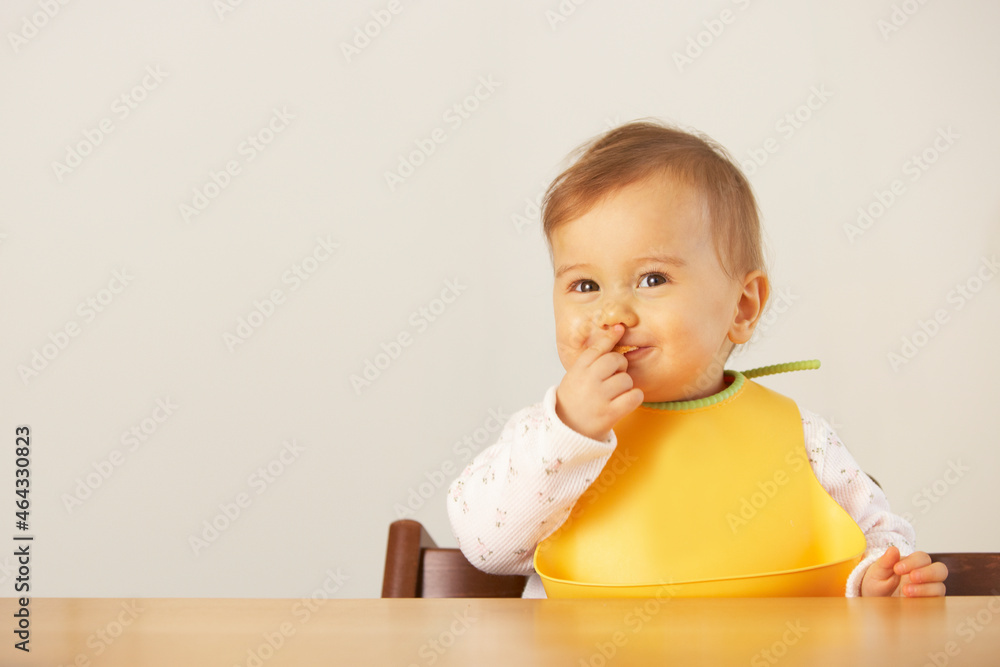 自分の手で食事を食べる笑顔の赤ちゃん 自分の手で食事を食べる笑顔の赤ちゃん