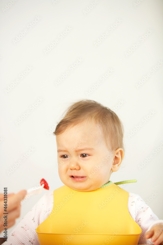 果物のイチゴをお母さんに食べさせてもらう赤ちゃん