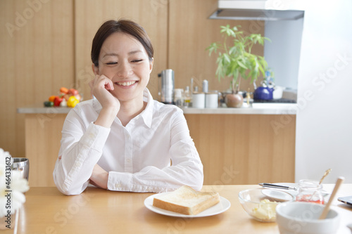 楽しそうに考え事をする女性の朝食風景