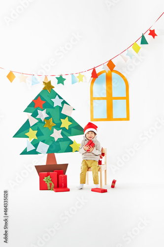 プレゼントボックスを持つ男の子とクリスマスツリー photo