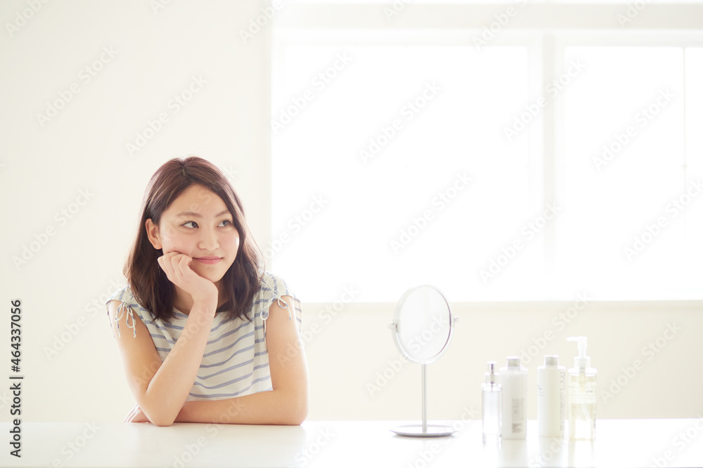 肘をついて遠くを見つめる若い女性 肘をついて遠くを見つめる若い女性