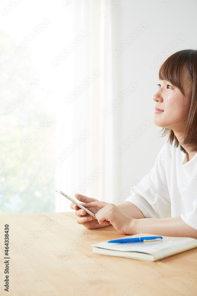 テーブルの上でスマホをする女性 テーブルの上でスマホをする女性