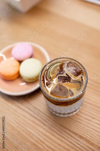 Macaroons in a box on a wooden table and ice coffee
