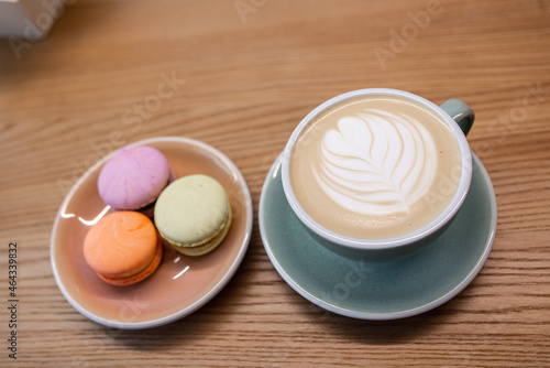 Macaroons in a box on a wooden table and cappuccino