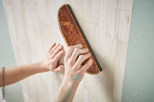 壁紙を貼る男性の手